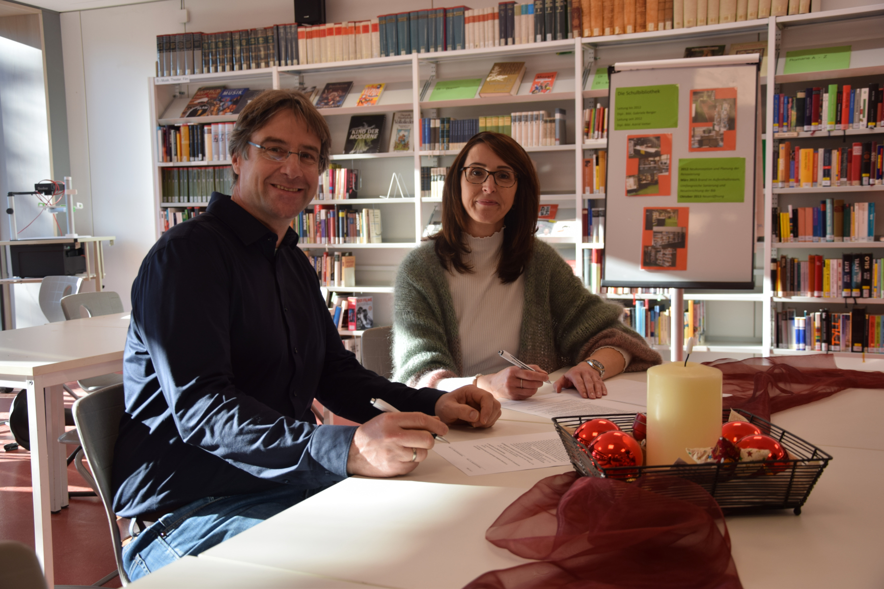 Foto (EG): Schulleiter Ingo Knesch und die Leiterin der Otto-Rombach-Bücherei Sandra Eichert bei der Unterzeichnung des Kooperationsvertrages. 