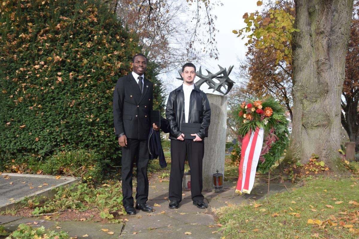 Foto (EG): Elvis Ugwueze und Samuel Bahro an der Gedenkstätte auf dem Friedhof St. Peter (von links)